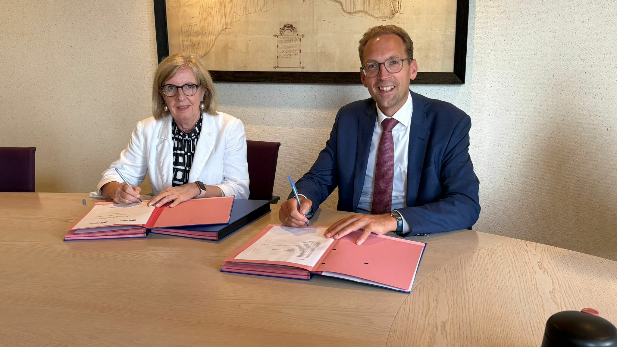 Wethouder Arjan Meerkerk en  Directeur Fien Wonen ondertekenen de overeenkomst voor de Nassaustraat