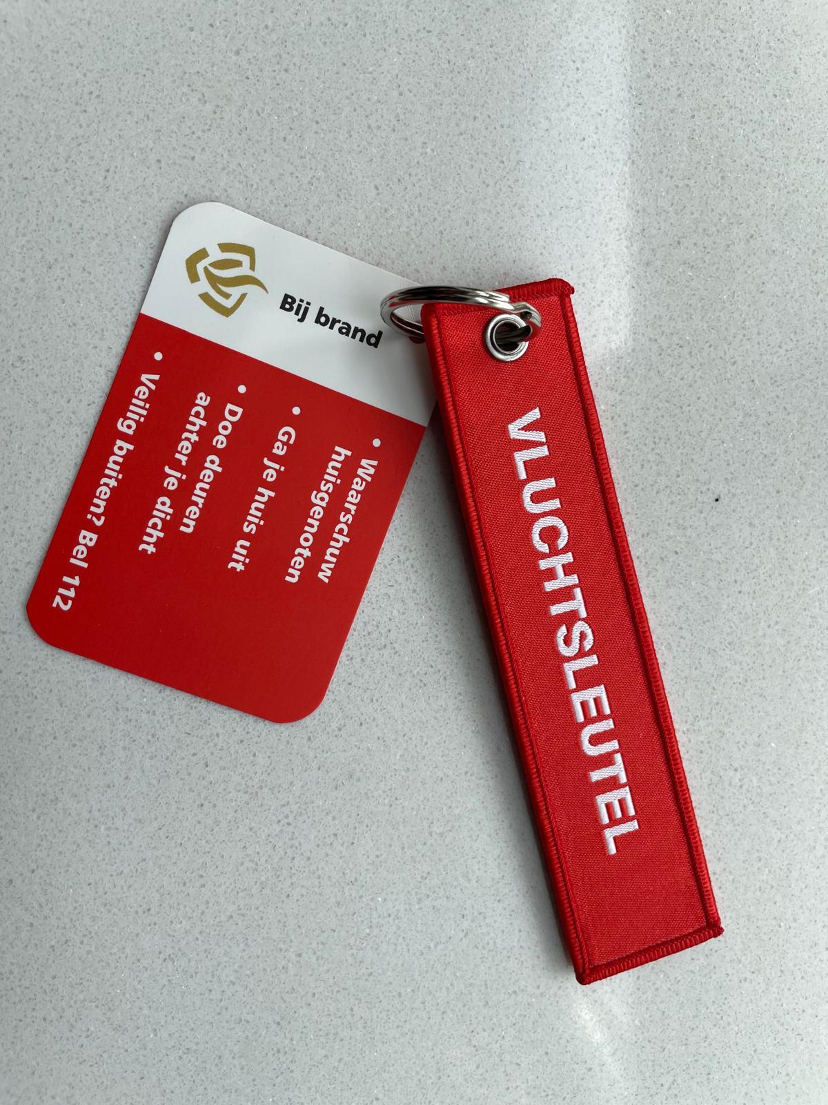 Vluchtsleutel en kaartje met tips bij brand: 1. Waarschuw huisgenoten. 2 Ga je huis uit. 3 Doe deuren achter je diicht. 4  Veilig buiten? bel 112